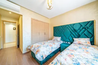 a bedroom with a bed and a large headboard at Résidence Coralia les orangers in Marrakech