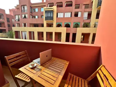 a laptop on a table on a balcony with a building at Appartement calme, Guéliz in Marrakech