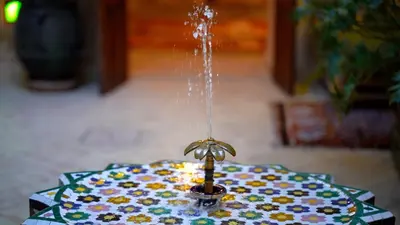 a water fountain in the middle of a table at Riad Chambres D'Amis Marrakech in Marrakech