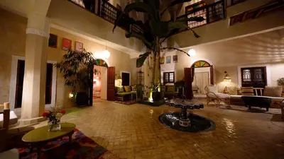 a lobby with a living room with a palm tree at Riad Chambres D'Amis Marrakech in Marrakech