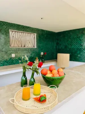 a table with two glasses of orange juice and a bowl of oranges at Riad Deha & Spa in Marrakech