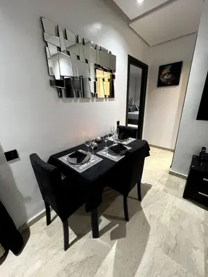 a dining room with a black table and chairs at Luxury apartment in center of gueliz in Marrakech