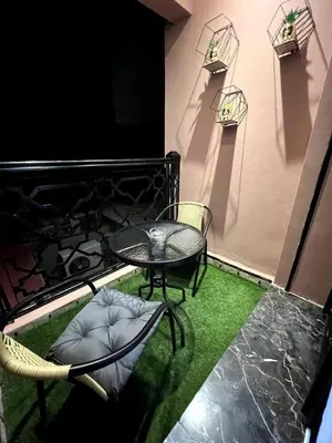 a table and chairs on a balcony with green grass at Luxury apartment in center of gueliz in Marrakech