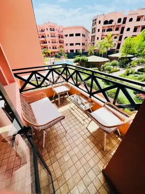 a balcony with chairs and tables on a building at Appartement Marrakech With Pool and View in Marrakech