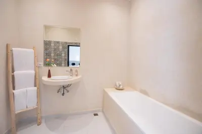 a white bathroom with a tub and a sink at Riad Albaraka in Marrakech