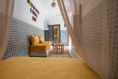a bedroom with a bed and a chair in a room at Riad Albaraka in Marrakech