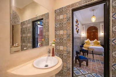 a bathroom with a sink and a bedroom with a bed at Riad Albaraka in Marrakech