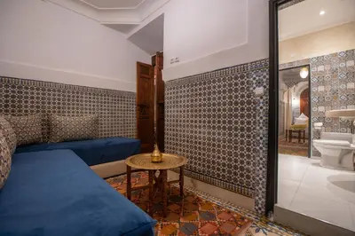 a room with a bed and a toilet and a table at Riad Albaraka in Marrakech