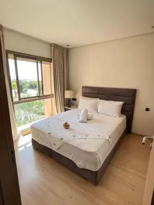 a bedroom with a large bed and a window at Appt Premium 3 rooms with big terrace at Prestigia Marrakech in Marrakech