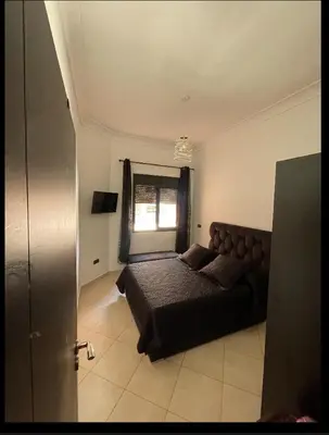 a bedroom with a large bed and a window at Appartement véranda marrakech in Marrakech