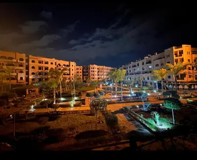 a city lit up at night with buildings and trees at Appartement véranda marrakech in Marrakech