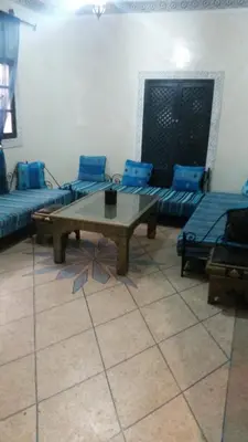 a living room with a coffee table and blue couches at appartement Bahia jame el fna in Marrakech