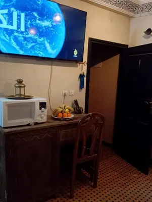a table with a microwave and a plate of fruit on it at appartement Bahia jame el fna in Marrakech