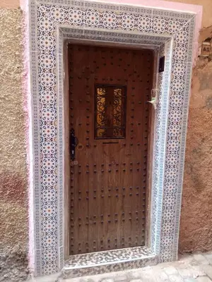a wooden door with a window on a building at appartement Bahia jame el fna in Marrakech