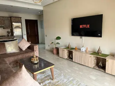 a living room with a couch and a tv on the wall at Golden house in Marrakech