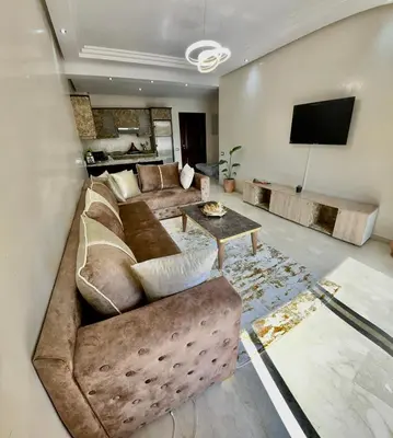 a living room with a couch and a flat screen tv at Golden house in Marrakech
