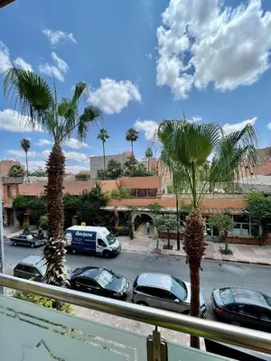 a view of a parking lot with cars and palm trees at Golden house in Marrakech