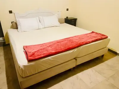a large white bed with a red blanket on it at Villa Baddi Marrakech in Marrakech