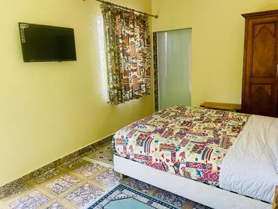 a bedroom with a bed and a television on the wall at Villa Baddi Marrakech in Marrakech