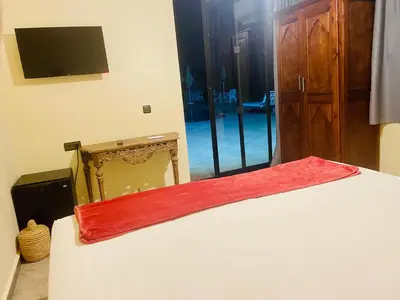 a bedroom with a bed with a red blanket on it at Villa Baddi Marrakech in Marrakech