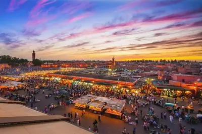 a crowd of people walking around a market at sunset at A Place To Call Home - Downtown in Marrakech