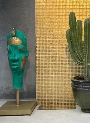 a green head on a stand next to a cactus at YVES Marrakech in Marrakech