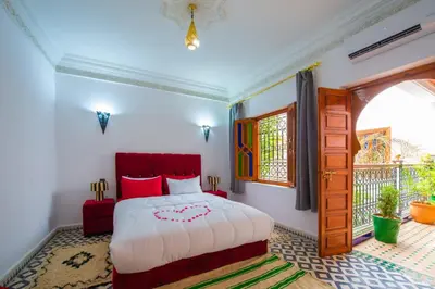 a bedroom with a bed and a window at Riad Amely in Marrakech