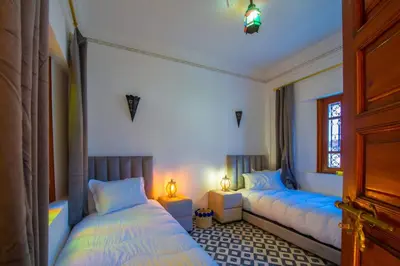 two beds in a room with blue beds in it at Riad Amely in Marrakech