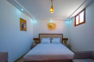 a bedroom with a white bed and a couch at Riad Amely in Marrakech