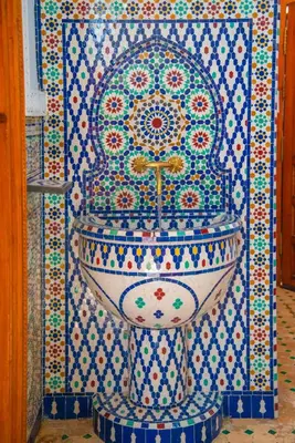 a bathroom with a sink on a tiled wall at Riad Amely in Marrakech