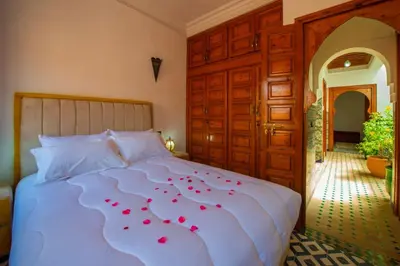 a bedroom with a bed with red roses on it at Riad Amely in Marrakech