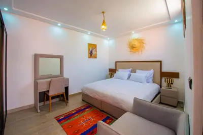 a bedroom with a bed and a desk and a mirror at Riad Amely in Marrakech