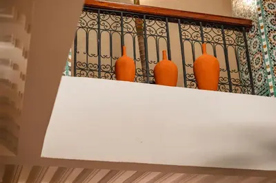 a row of orange vases sitting on a shelf at Riad Privé Dar L'Étoile - Jacuzzi Piscine & Petit Déj inclus in Marrakech