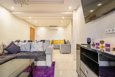 a living room with a couch and a table at Magnifique Appartement lux - Perles de Coralia in Marrakech