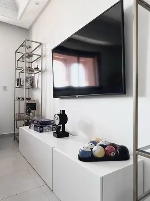a living room with a television on a white wall at Jardin Majorelle Cozy Apartment in Marrakech
