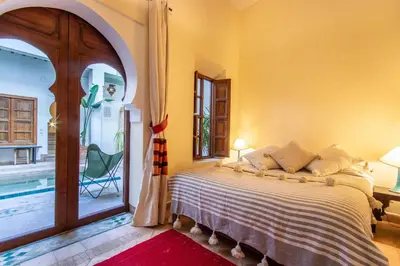 a bedroom with a bed and a door to a patio at Riad Dar Al Barakaa - EXCLUSIVE - Breakfast in Marrakech