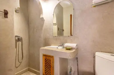 a bathroom with a sink and a mirror and a toilet at Riad Dar Al Barakaa - EXCLUSIVE - Breakfast in Marrakech