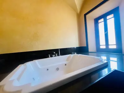 a large white tub in a bathroom with a window at Majestic Luxury Villa Marrakech in Marrakech