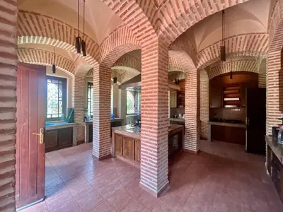 a large kitchen with arched ceilings and a red door at Majestic Luxury Villa Marrakech in Marrakech