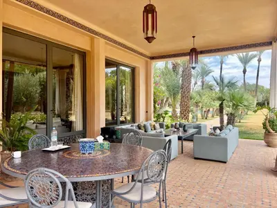 an outdoor patio with a table and chairs at Majestic Luxury Villa Marrakech in Marrakech