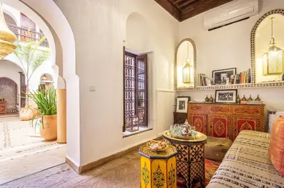 a living room with a couch and a table at Riad El Faris Exclusif-Included Moroccan Breakfast in Marrakech