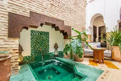 a swimming pool in the middle of a living room at Riad El Faris Exclusif-Included Moroccan Breakfast in Marrakech