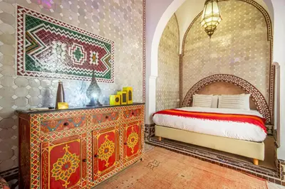 a bedroom with a bed and a dresser at Riad El Faris Exclusif-Included Moroccan Breakfast in Marrakech