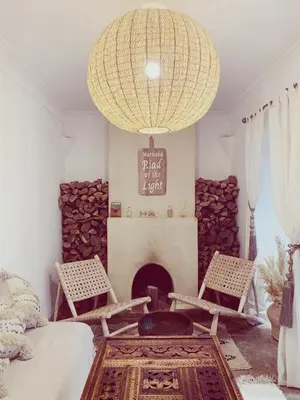 a room with a fireplace and two chairs and a chandelier at Riad of The Light in Marrakech