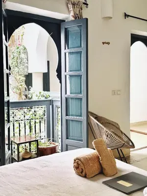 a room with a bed and a chair and a window at Riad of The Light in Marrakech