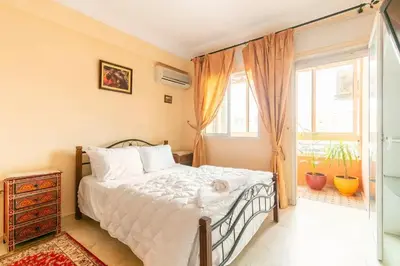 a bedroom with a bed with a cat laying on it at Appartement spacieux Centre Marrakech in Marrakech