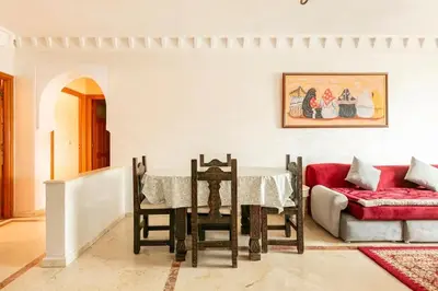 a dining room with a table and a red couch at Appartement spacieux Centre Marrakech in Marrakech