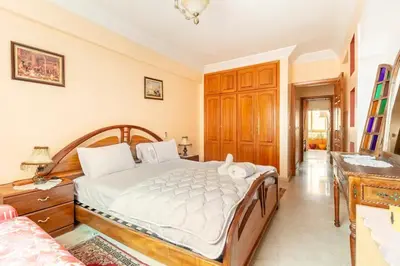 a bedroom with a large bed and a desk at Appartement spacieux Centre Marrakech in Marrakech