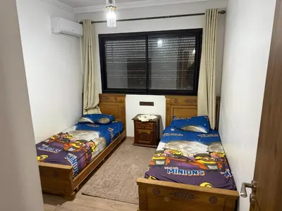 two beds in a small room with a window at Appartement Nour 5 Marrakech in Marrakech