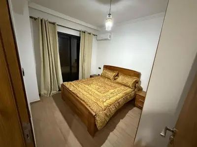 a bedroom with a bed in a room with a window at Appartement Nour 5 Marrakech in Marrakech